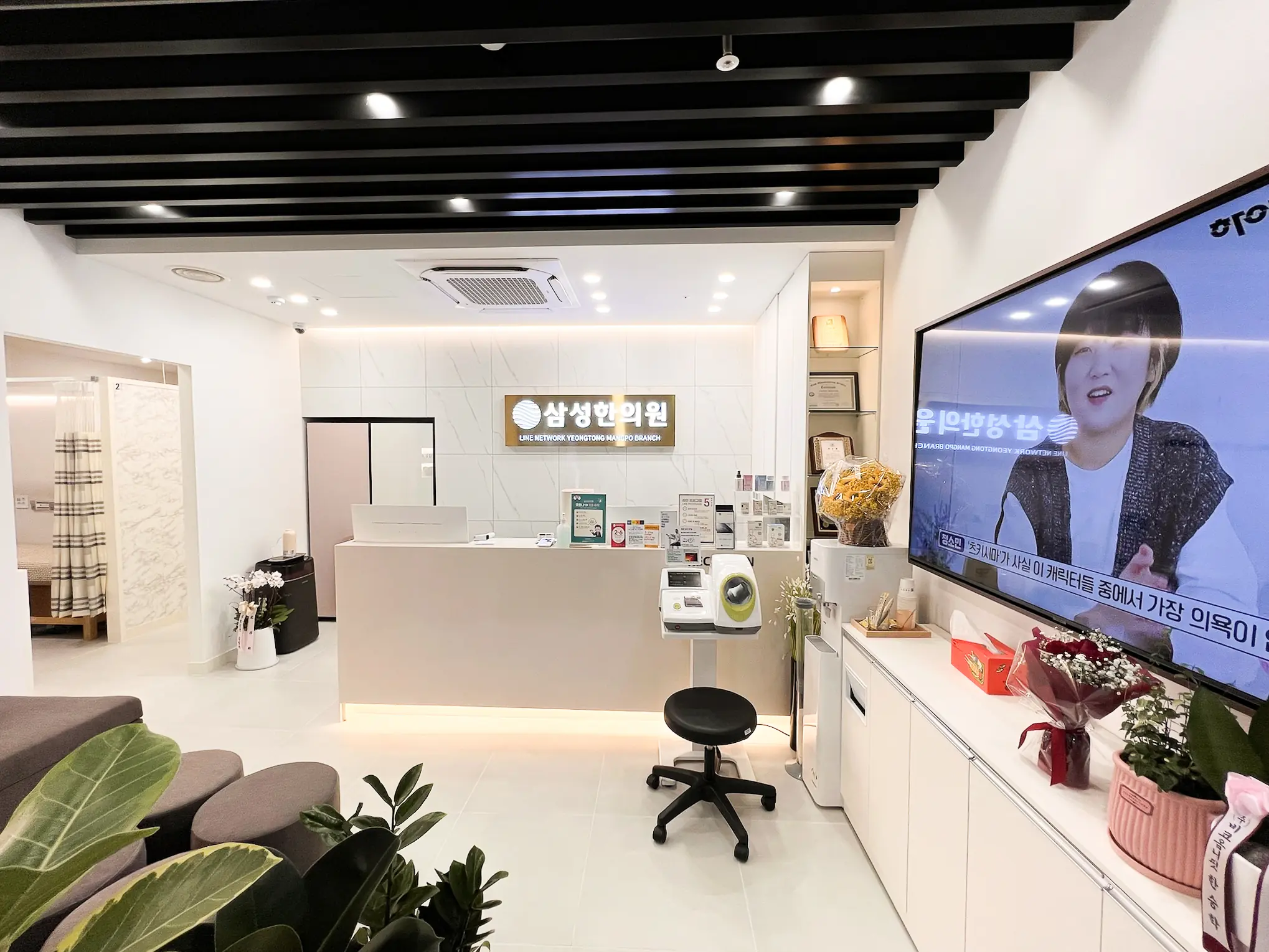 영통삼성한의원 접수대와 블랙 루버 천장 전경